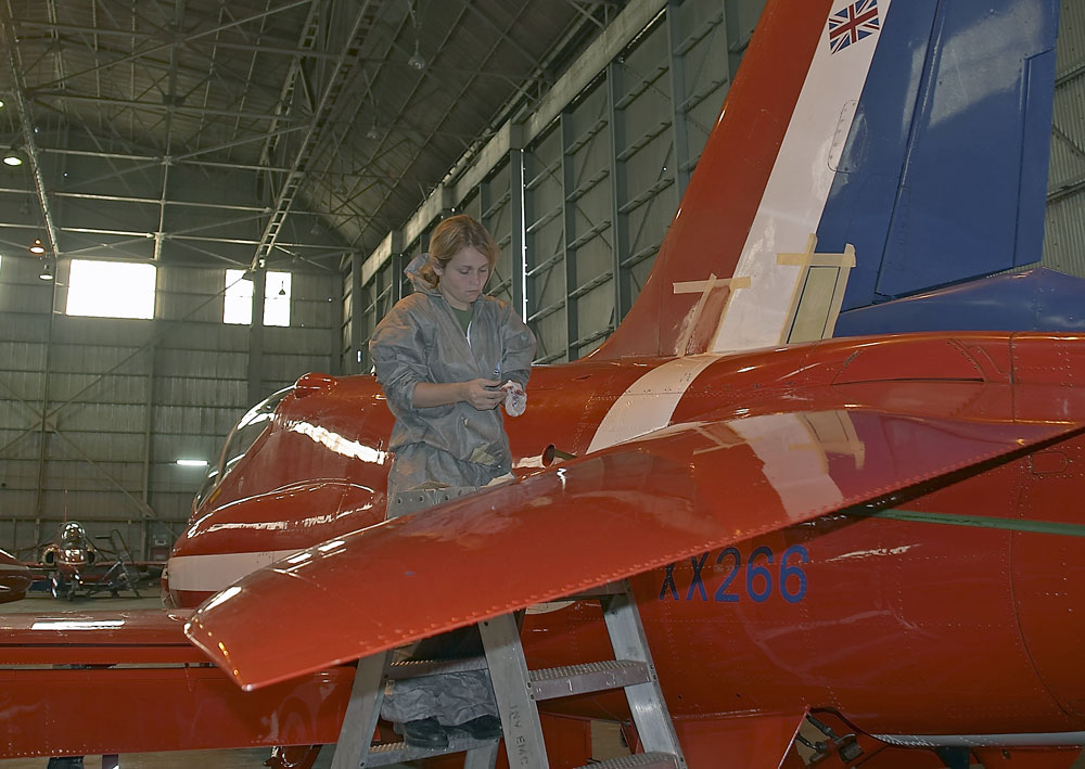 Taking great pride in her work this painter prepares another jet for the team